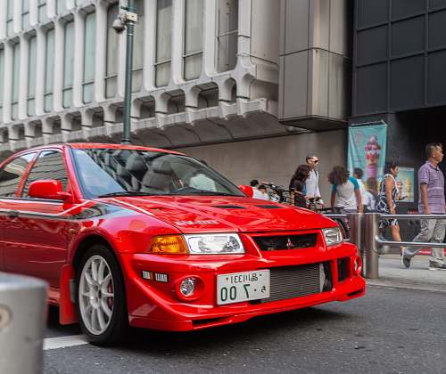 automobile red Mitsubishi vehicle on road transportation