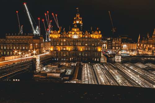 edinburgh city with fireworks display during nighttime construction crane