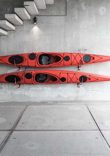 denmark two red kayaks hanging on wall under stairs wall
