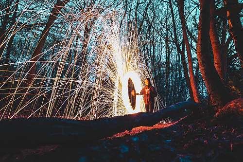 sparks woman in the middle of forest steelwool photo night