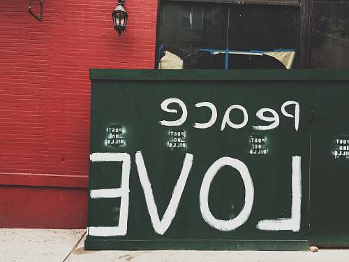 structure Peace Love painted on green wall peace