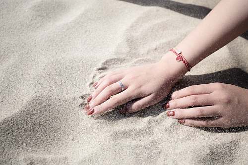 sand woman lying on white sand hands