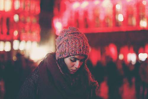 cap woman surrounded by people in city beanie