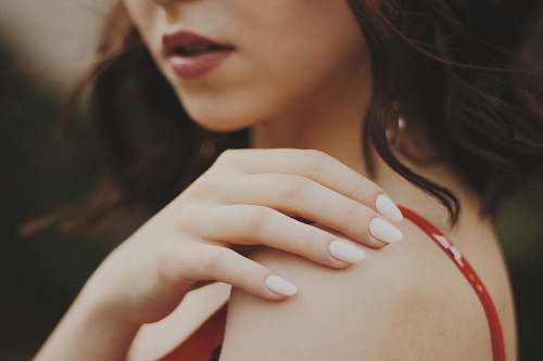 person close-up of woman in red spaghetti strap top finger