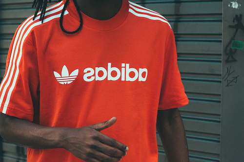 person man wearing red and white adidas crew-neck T-shirt people