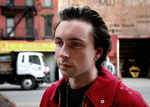 person man wearing red jacket selective focus photography people