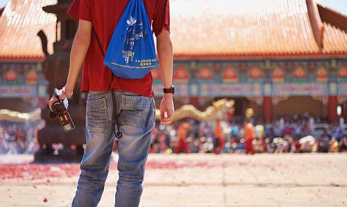 person man wearing red shirt holding video camera bag