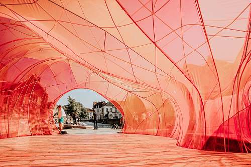 person people walking underneath red cloth path