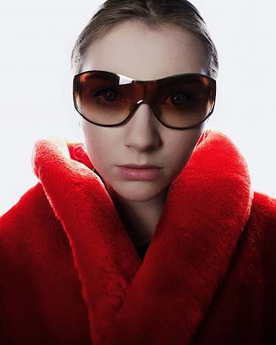 people woman in red coat wearing brown sunglasses person