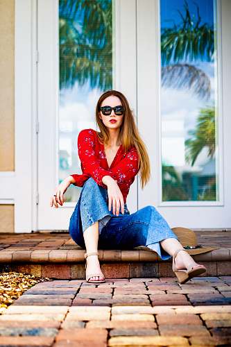 people woman wearing blue jeans sitting on floor person