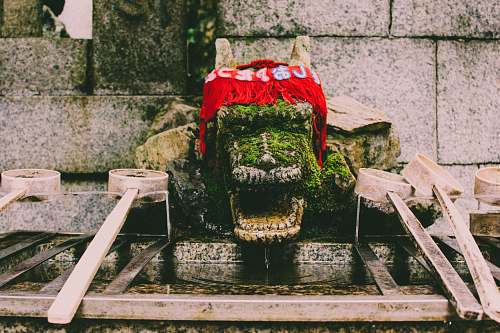 moss red knitted textile on top og green dragon statue fushimi inari taisha