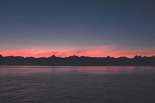 outdoors body of water near mountain during blue hour sunset
