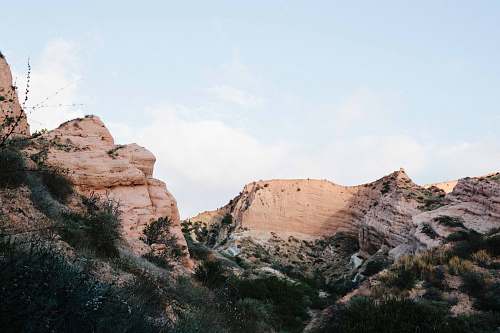 desert brown rock formation with green bushes landscape