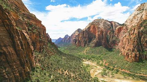 mountain green plants and trees between brown cliff during daytime valley