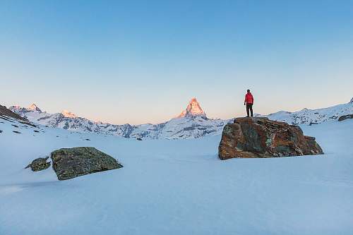 snow man standing on rock during daytime ice