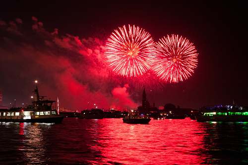 outdoors red fireworks during daytime boat