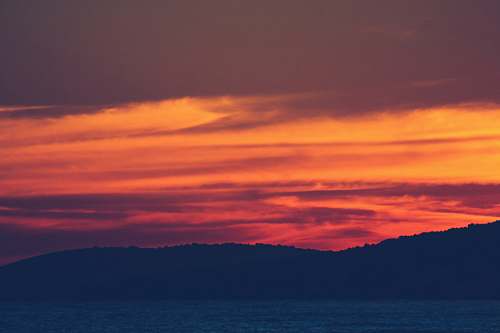 outdoors silhouette of mountains near body of water sky