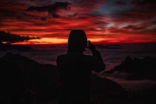 outdoors silhouette photography of person looking at the sea during golden hour human