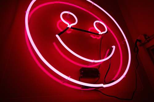 red pink emoji neon signage smiley face
