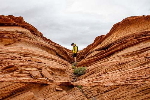 nature person in between rock formation during daytime desert