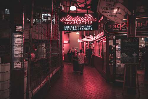 human people walking in lobby during nighttime neon