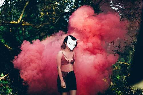 woman woman standing in front of red smoke mask