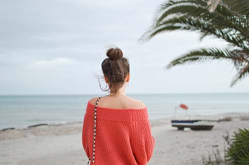 person woman wearing red knitted sweater standing on the beach human
