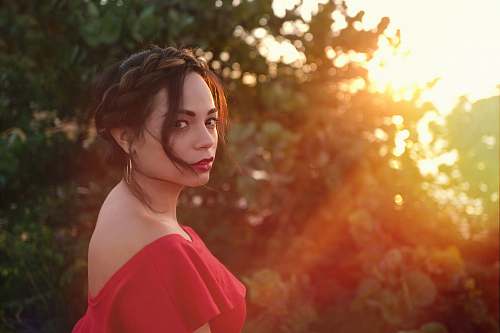 woman woman wearing red top near green leafed tree female