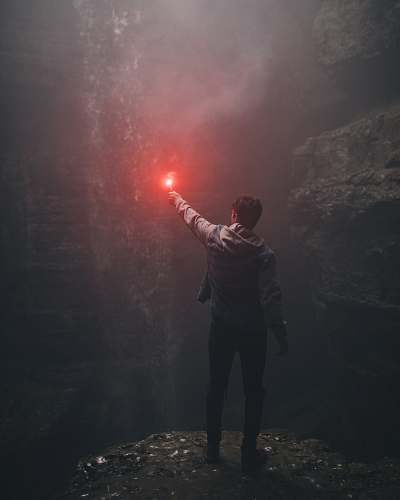 people man lighting up flare in cave human