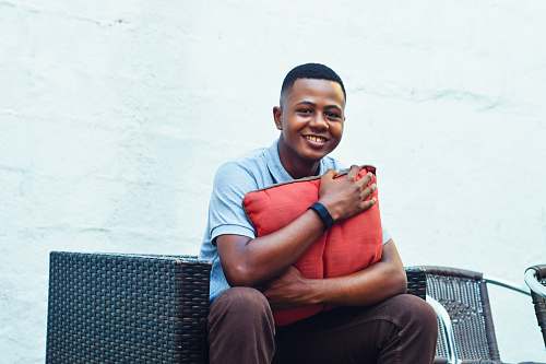 human man sitting on sofa near white painted wall people