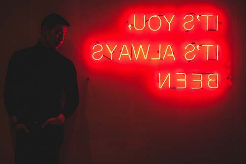 people man standing beside red LED sign human
