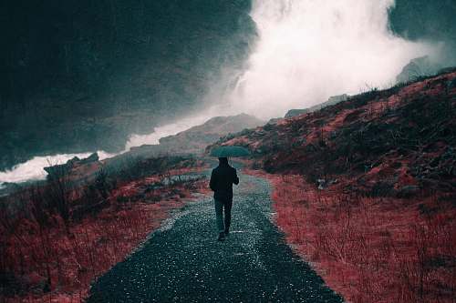 norway painting of man walking down a road holding umbrella rain