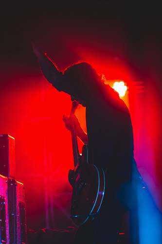 human person on stage holding guitar crowd