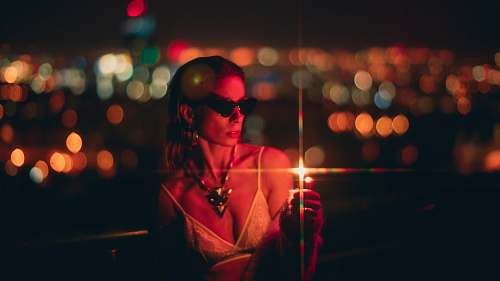 human woman holding lighter at night sunglasses