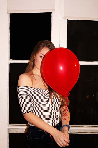 human woman holding red balloon balloon