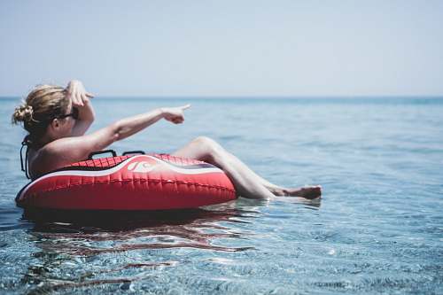 people Woman on an inflatable float in the ocean pointing with a finger at Posidi human