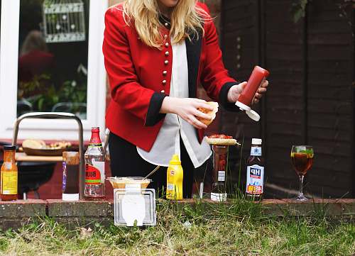 people woman putting red sauce on hamburger bbq