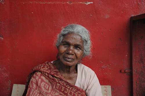 human woman sitting near red painted wall people