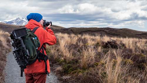 photography person wearing backpack and holding DSLR camera backpack