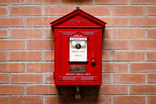 mailbox red fire alarm station attached on brick wall red