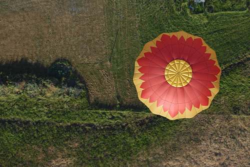 green aerial photo of hot air balloon flying in the air central point
