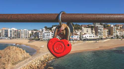 love heart padlock hanging on brown pipe ocean