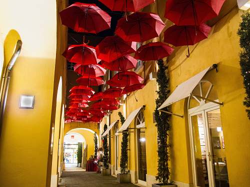 yellow pathway covered by red umbrellas building