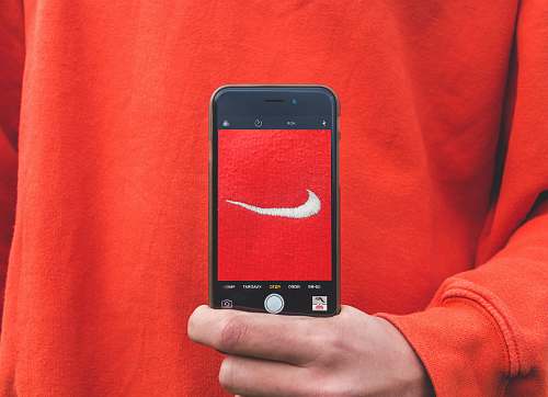 phone person holding iPhone taking picture on Nike label skjød