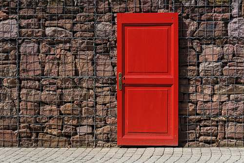 germany red 2-panel door on black metal chain link board brick