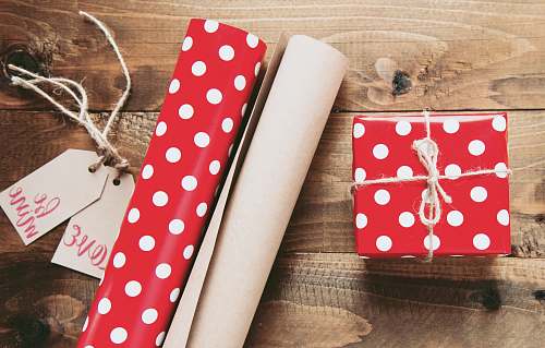 gift red and white polka-dot gift box beside gift wrappers table