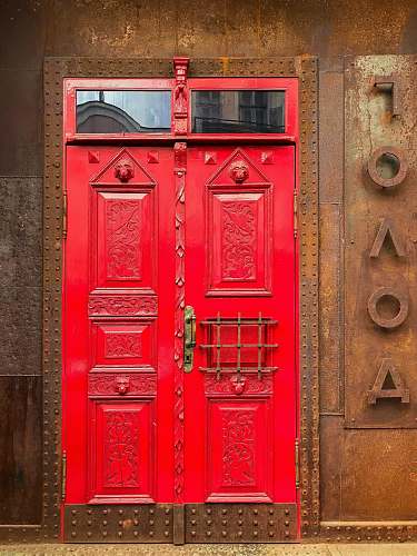 door red painted door on brown rustic metal wall path