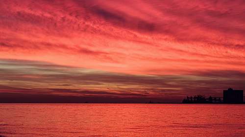 sunset silhouette of structure under red sky sunrise
