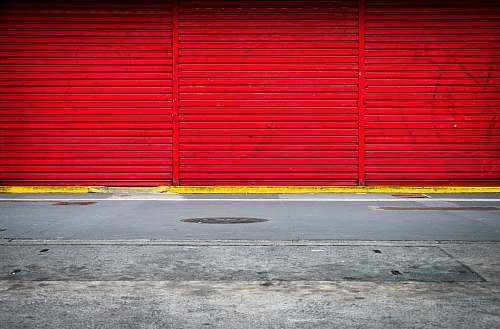 asphalt three panels of red roll up doors closed tarmac