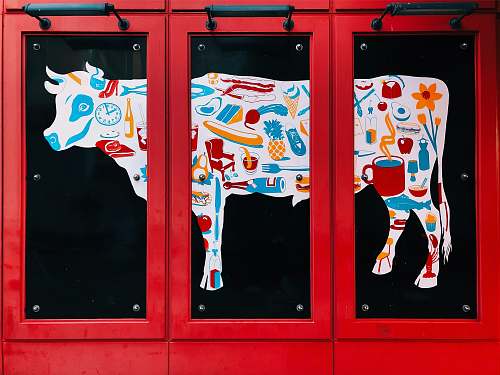 poster white, blue, and red cow 3-panel painting on wall cow